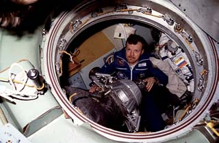 Arrival of Mir-23 crew from Soyuz into Mir Space Station node. Evald Reinhold holds probe inside the entrance of the Soyuz spacecraft. 